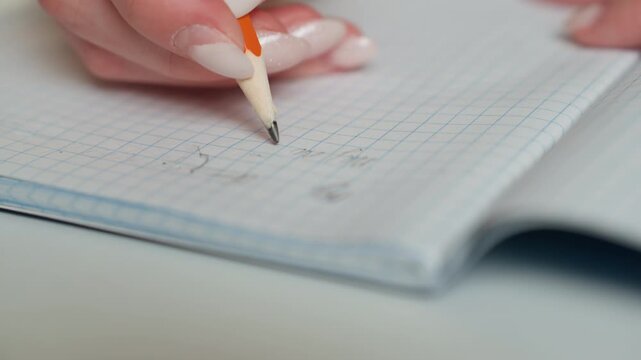 Closeup manicure hand marking homework in graph notebook, precise pencil marks, neat correction ticks, positive feedback vibe, coach review mood, bright daytime desk, progress and improvement