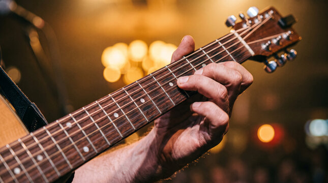 Close-up of Guitarist Fingers Pressing Acoustic Guitar Strings on Stage