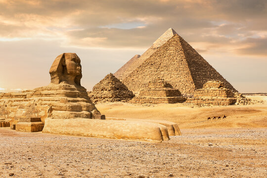 The majestic Sphinx sits before the pyramids in the Giza desert during a dramatic Egyptian sunset