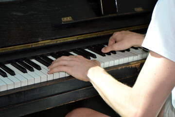 Close-up of hands playing old upright piano keys for music background and practice banner design © iri.madrid.art
