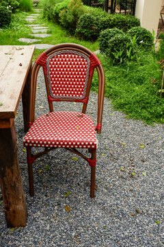 Luxury chair and wooden table set in english garden on a sunny day,outdoor seating for restaurant or cafe,Near paver patio with sitting area and small garden in forest.