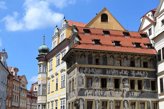 Prague sgraffito decorated historic building with red tiled roof and tower for travel banner and architectural background