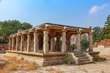 Fototapeta premium Ancient stone temple ruins and historic carved architecture in Hampi, India. Beautiful landscape with archaeological site, cultural heritage landmark and popular international tourist destination.
