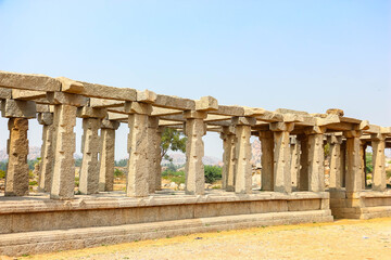 Fototapeta premium Ancient stone temple ruins and historic carved architecture in Hampi, India. Beautiful landscape with archaeological site, cultural heritage landmark and popular international tourist destination.