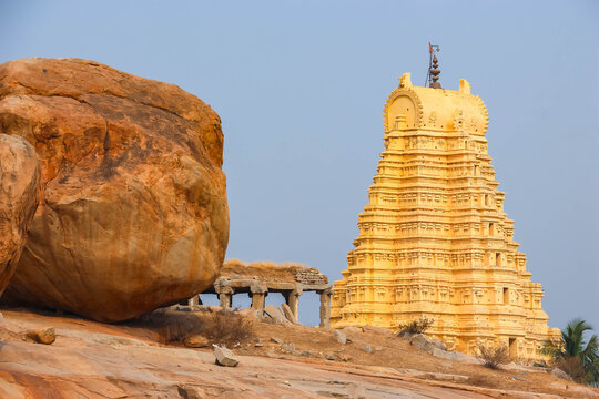 Ancient stone temple ruins and historic carved architecture in Hampi, India. Beautiful landscape with archaeological site, cultural heritage landmark and popular international tourist destination.