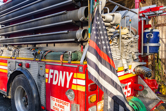 New York, USA - February 20, 2026: Side view of FDNY fire engine showing large logo lettering emergency hoses and a patriotic thin red line flag