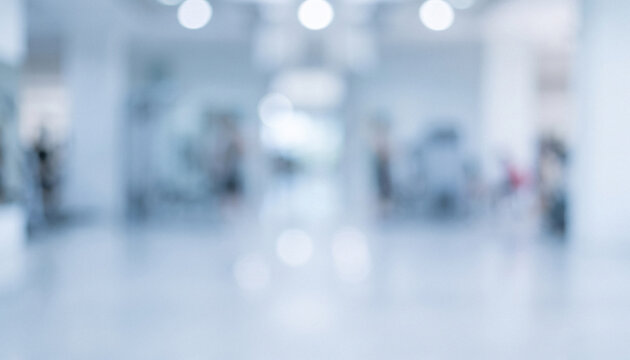 Abstract blurred view of a modern interior space, featuring soft lighting and vague outlines of people in a spacious environment.