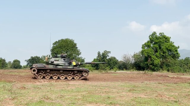 THAILAND - AUGUST 9, 2026: Heavy military battle tank operating in field training grounds, showing external armor tracks and interior tactical command cockpit equipment inside a restricted military zo