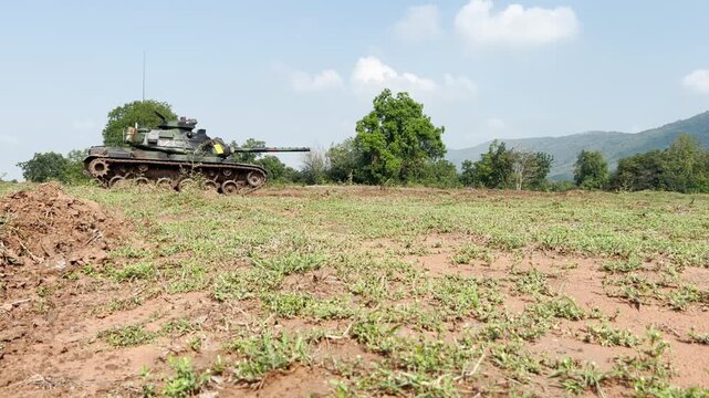 THAILAND - AUGUST 9, 2026: Heavy military battle tank operating in field training grounds, showing external armor tracks and interior tactical command cockpit equipment inside a restricted m