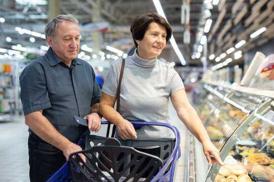 Married couple choose groceries together in supermarket
