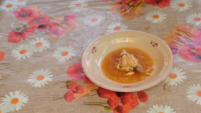 Adding home made soup with hot dog and potato to rustic table with dripping around