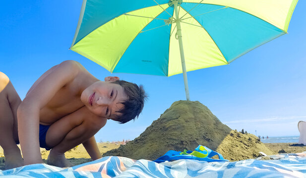 Bambino sulla spiaggia di Caorle che gioca e ride in costume