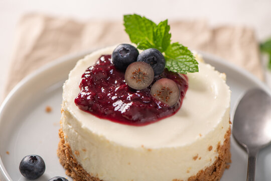 Mini cheesecake with berry compote and fresh blueberries on a plate