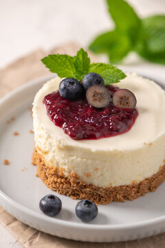 Mini cheesecake with berry compote and fresh blueberries on a plate