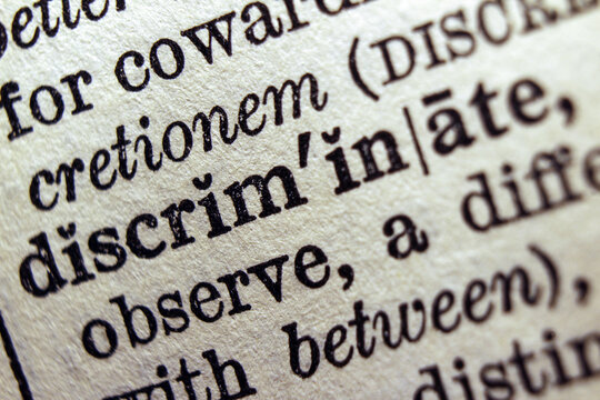 Word discrimination printed on dictionary page, macro close up.