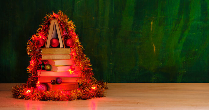giving books for christmas,christmas gift,present,reading,literature,education, christmas,holiday concept with heap of books, christmas lights and decoration 