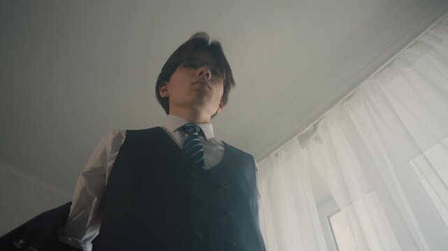 Asian man putting on jacket before meeting, lowangle cinematic shot of startup founder adjusting tie and posture, poised authority, soft window light through curtains, ready for presentation,
