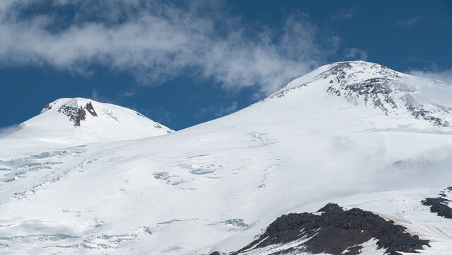 Snow-covered mountains Elbrus under a blue sky in summer
