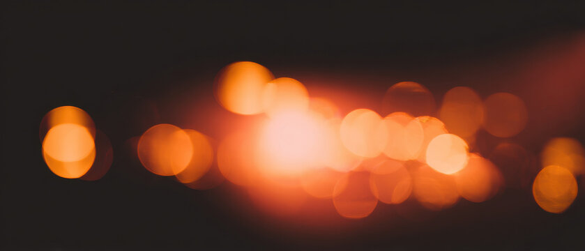 glowing amber bokeh orbs drift across dark night to inspire cozy web design banner and wallpaper
