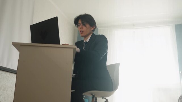 Speaker presenting at conference. Individual addressing audience on stage. Professional presenter confidently delivering speech during conference rehearsal with visual aids and stage lighting