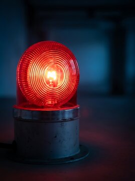 Glowing red emergency light in dark setting warning light
