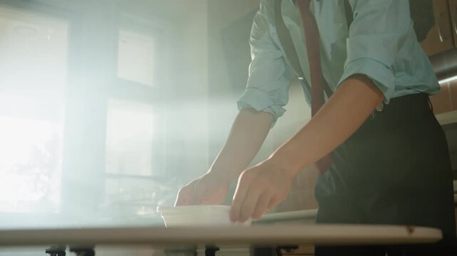 Asian man clutching mug near microwave, sunlit kitchen with suspenders and tie, bitter sip causes cough and grimace, tense cinematic atmosphere, solitary wakeup ritual disrupted, home interior