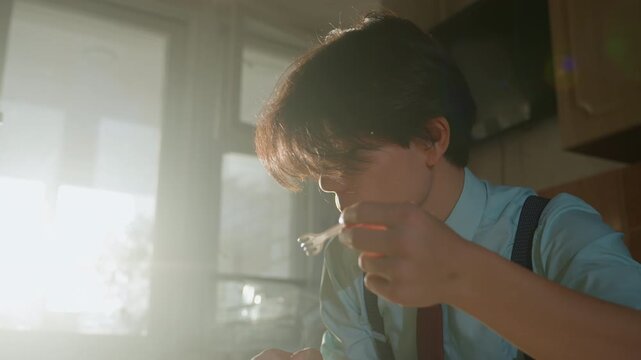 Asian young man tasting soup in sunlit kitchen, wearing shirt tie and suspenders, slow deliberate sip and thoughtful gaze, closeup backlit portrait with soft steam glow and warm flare, vintage
