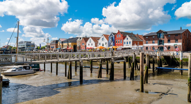 Husum, Germany. Husum's historic harbor at low tide reveals mudflats, harbor bridges, mooring facilities and the distinctive Husumer Speicher building.