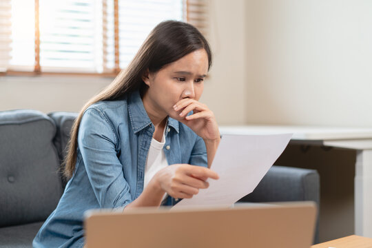 stressed young asian woman trying to find money to pay credit card debt