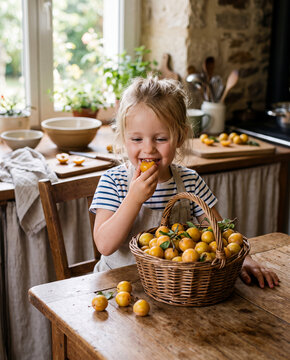 petite fille goutant une mirabelle