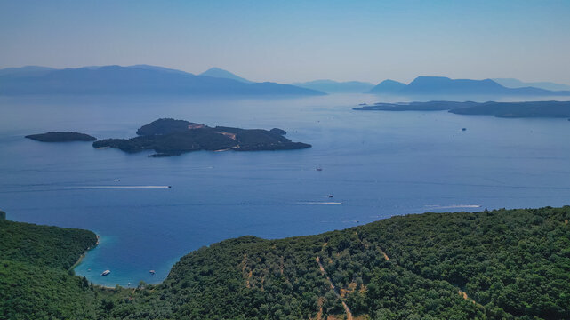 Panoramic drone view of Skorpios and Meganisi islands in Ionian Sea off eastern coast of Lefkada Greece with boats sailing on turquoise water for summer holiday