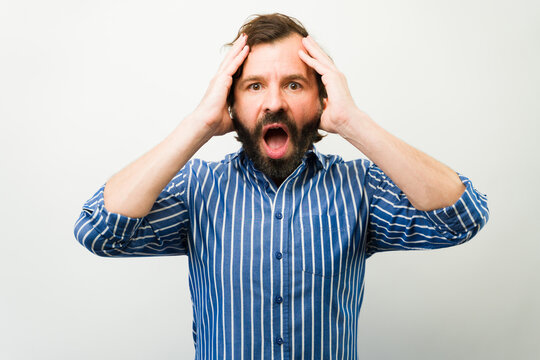 Frustrated man feeling stress and anxiety, opening mouth in shock and disbelief, reacting to bad news