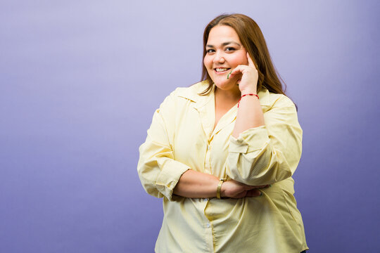 Plus-size woman smiling broadly, feeling confident and happy, embracing body positivity, and showing self-acceptance