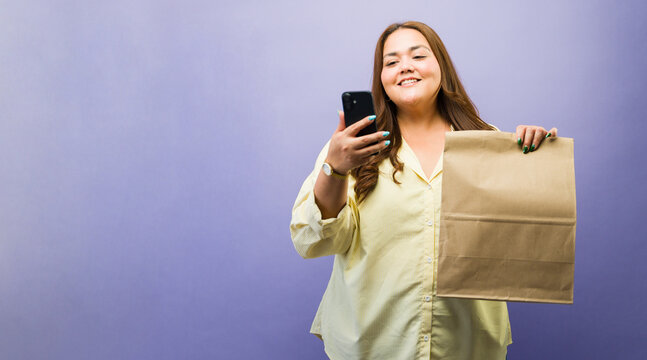 Happy woman creating social media content with a received order, showing her food delivery or groceries