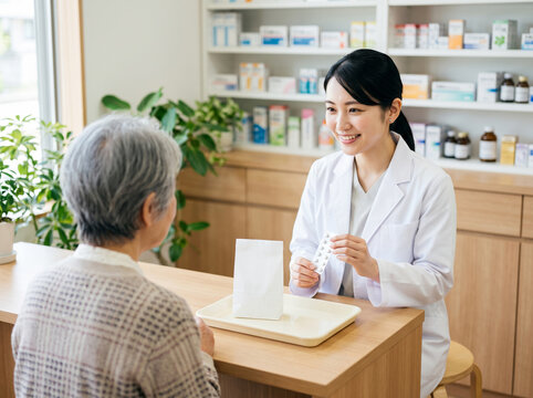 薬局カウンターで錠剤シートを見せながら説明する笑顔の薬剤師