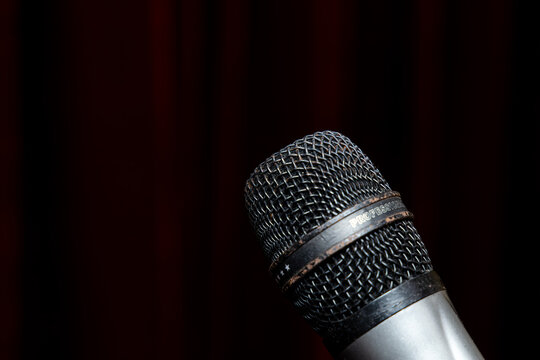 Microphone stands ready for a performance on stage during a live event in the evening