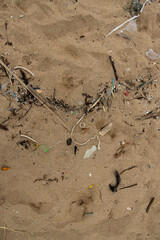 Obraz premium Trash and debris scattered on sandy beach near the ocean