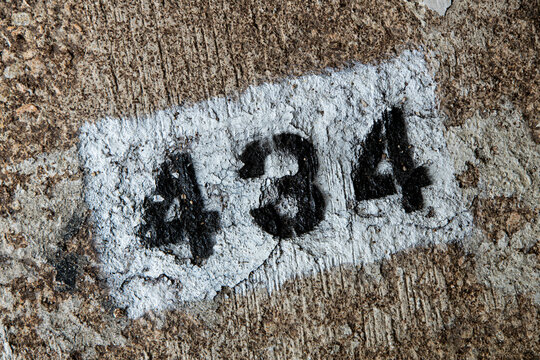 House number 434 painted on a wall showing signs of wear and age