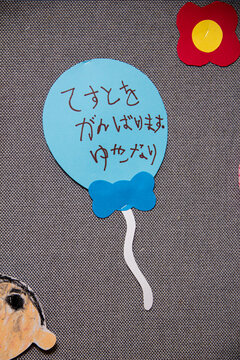 Blue balloon with handwritten message on a wall during an art display