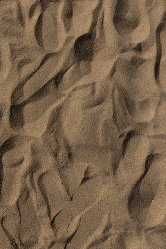 Footprints on sandy beach during sunny day