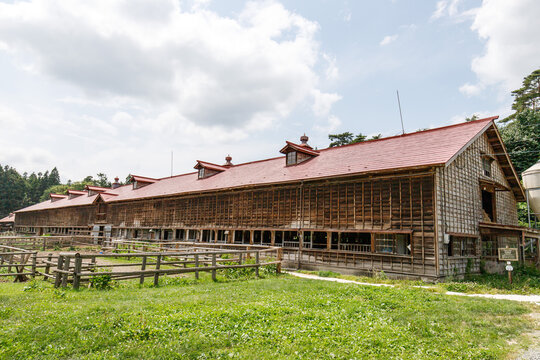 Large Historic Wooden Farm Barn with Red Roof and Fenced Pasture