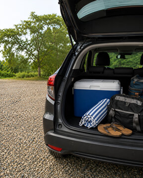 Packed car trunk with travel luggage and cooler