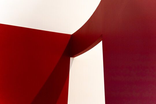 Abstract minimalist architecture featuring striking red walls, geometric shadows, and clean copy space. Ideal for modern B2B conceptual backgrounds.