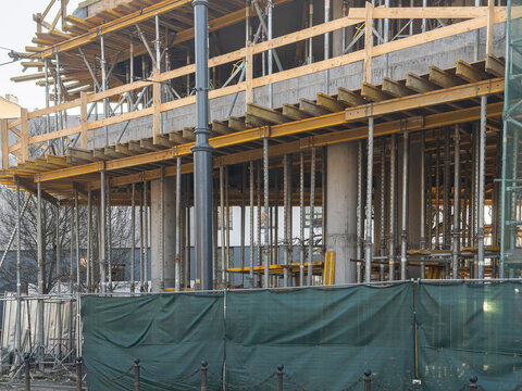 A building structure under construction with metal scaffolding and wooden supports, reflecting urban development, architectural progress, and the industrial growth of a modern city