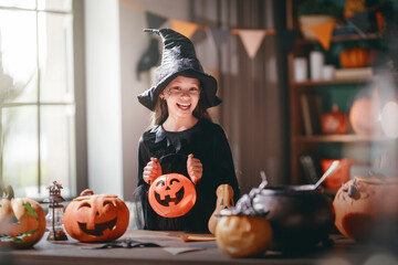 Obraz premium Smiling Child Dressed as Witch Celebrating Halloween