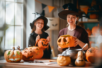 Obraz premium Happy Mother and Daughter Carving Pumpkins Together for Halloween