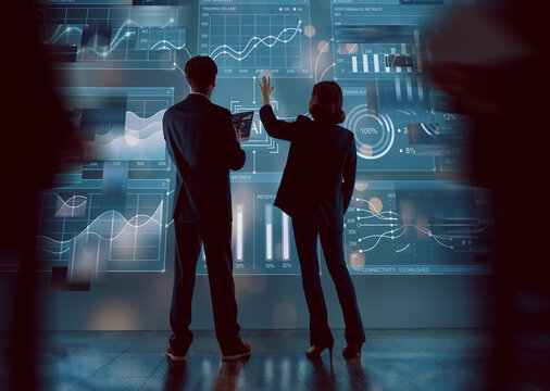 Business Professionals Analyzing Data on Futuristic Interactive Display