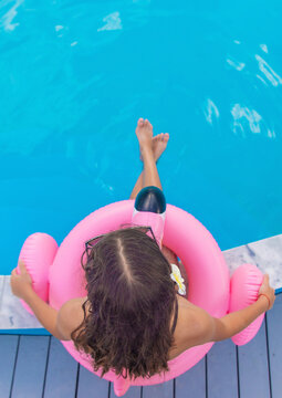 A teenage girl relaxing by the pool. Selective focus.