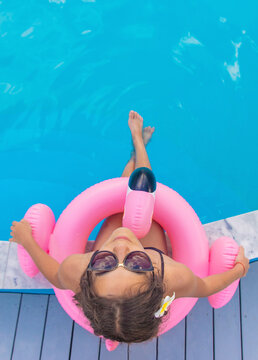 A teenage girl relaxing by the pool. Selective focus.