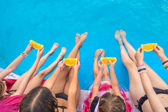Children eating watermelon by the pool. Selective focus.